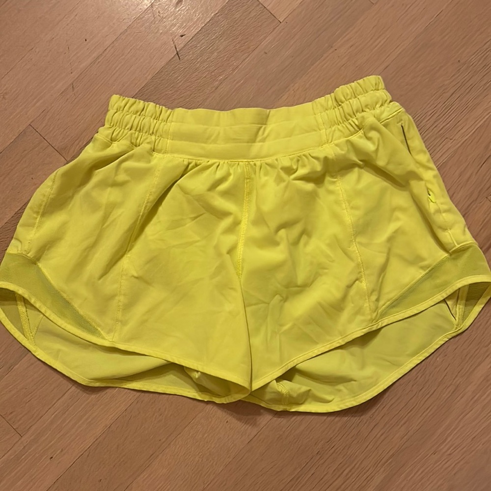 Highlight yellow Lululemon four inch hottie hot shorts.